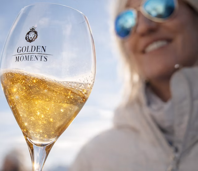 Golden Moments Sparkling Wine im Glas mit glitzerndem Goldstaub